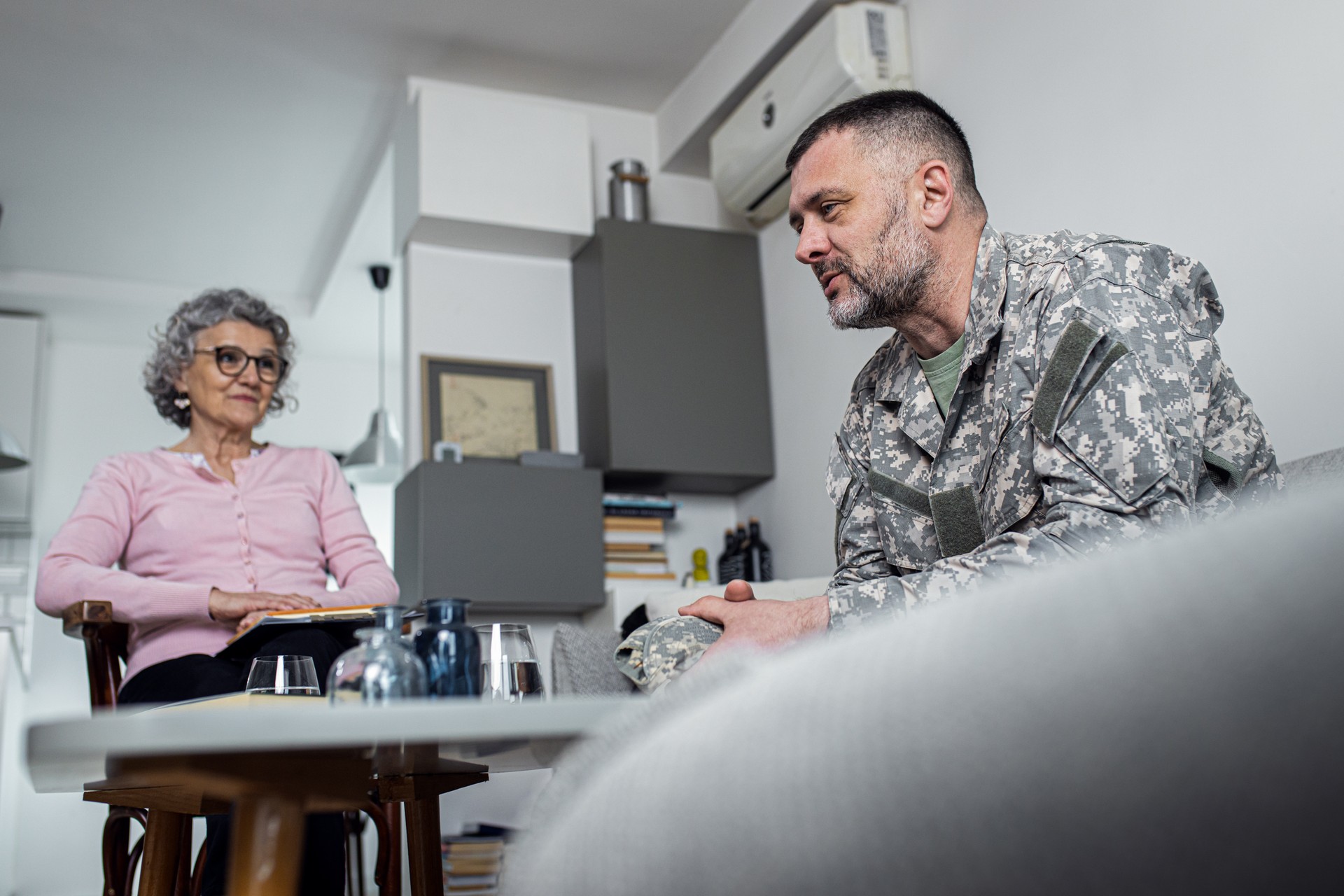 Soldier having therapy meeting with senior female psychologist.